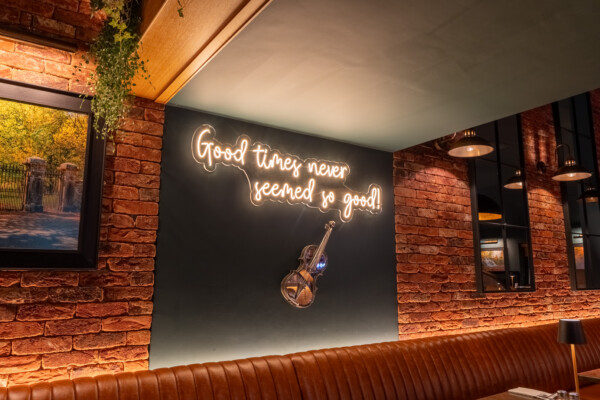 Feature wall with illuminated signage and exposed brick backdrop